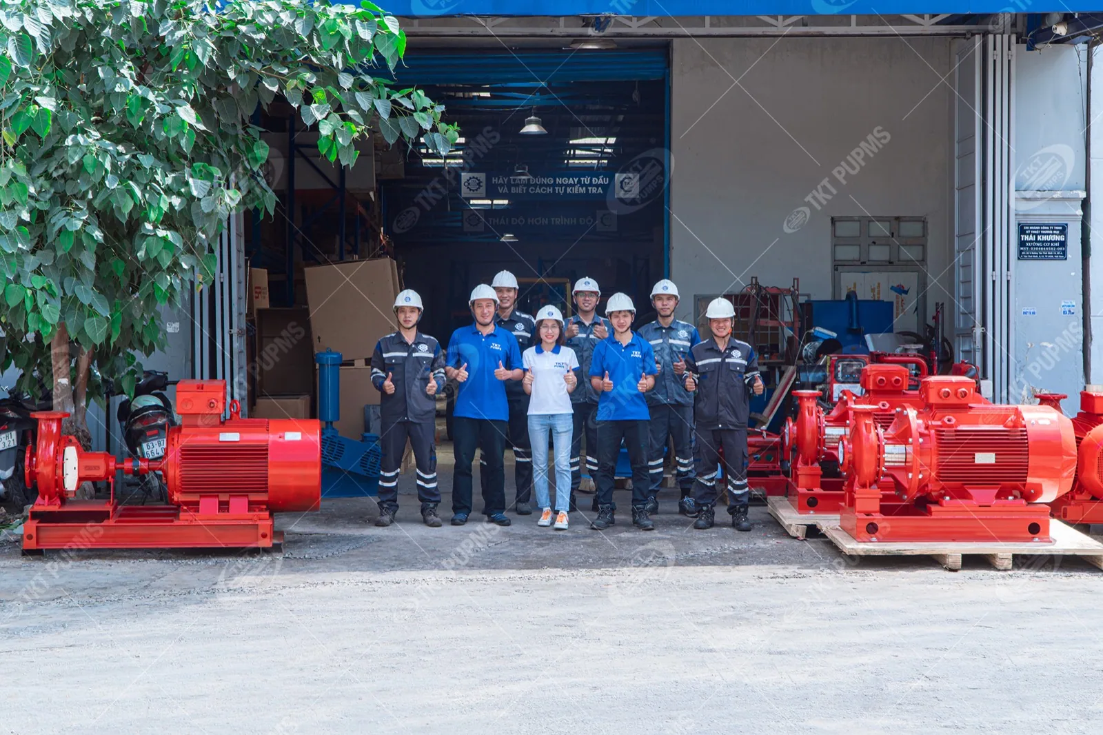 Cung cấp cụm bơm chữa cháy cho dự án bệnh viện và trung tâm nghiên cứu 2 Đội kỹ sư Thái Khương Services trước cửa xưởng, hai bên là các tổ bơm chữa cháy trên bệ đế đỏ