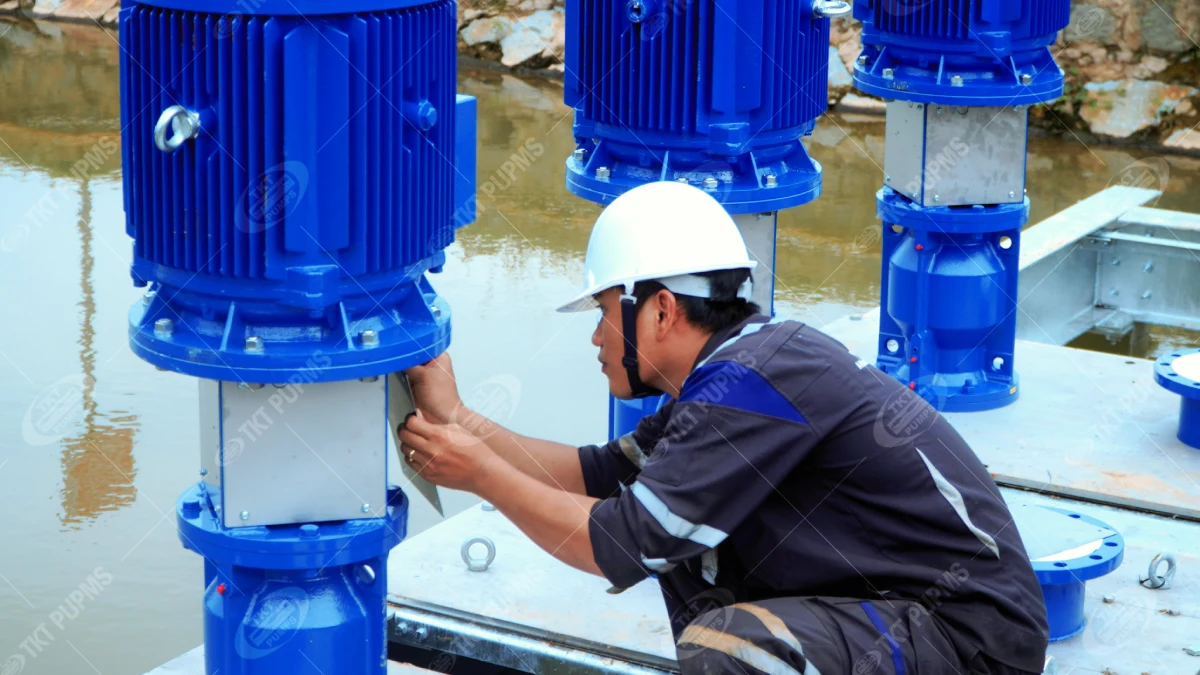 Khi bơm chìm không phải lựa chọn duy nhất – Thái Khương Pumps cấp 3 bơm cantilever cho ứng dụng bơm nước thải 8 Kỹ sư siết bu lông ở đầu bơm cantilever, ba cụm động cơ nằm trên sàn phía trên mực nước