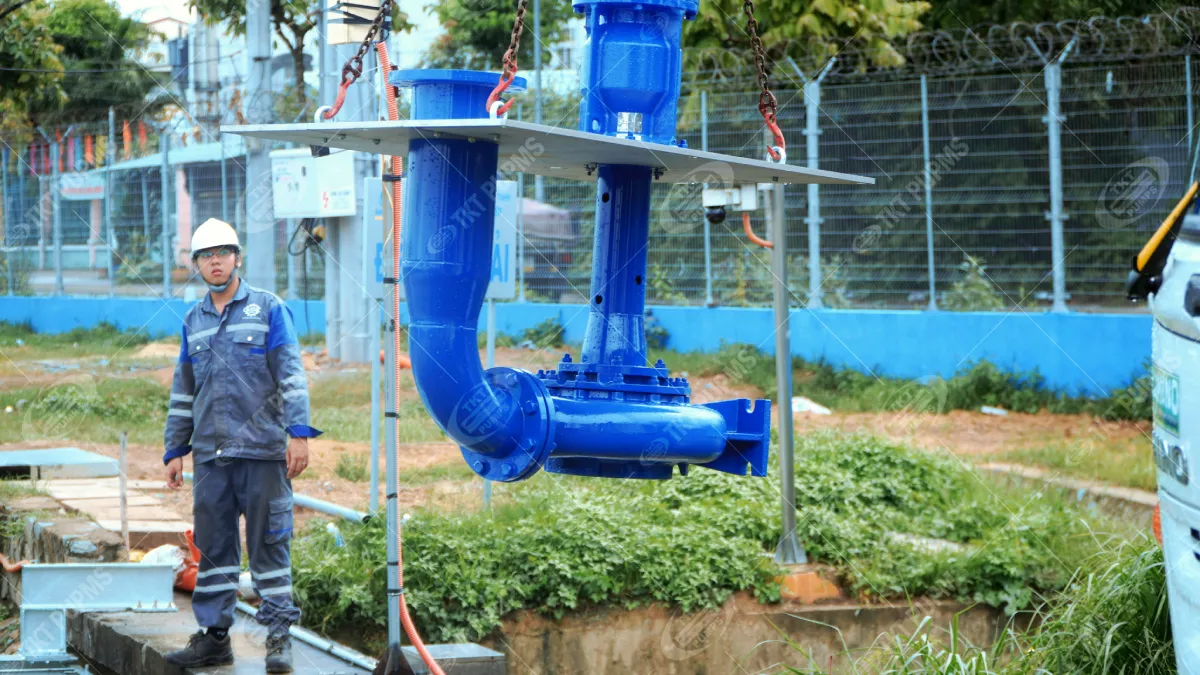 Khi bơm chìm không phải lựa chọn duy nhất – Thái Khương Pumps cấp 3 bơm cantilever cho ứng dụng bơm nước thải 4 Bơm cantilever treo trên móc cẩu tại công trường, kỹ sư Thái Khương đứng canh hướng hạ máy